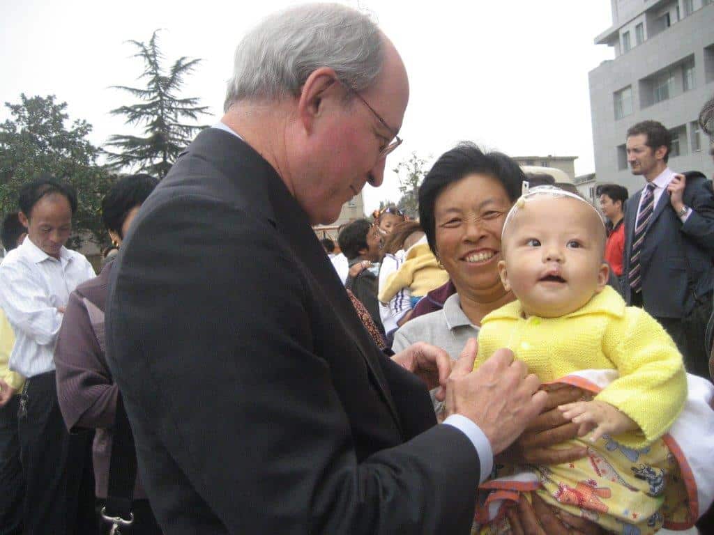 man in suit looking at Asian young boy