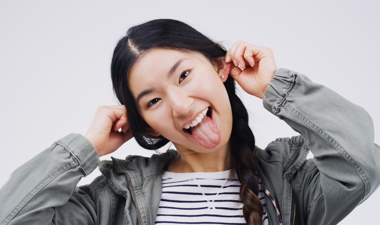 Studio shot of a young woman making a funny face against a gray background