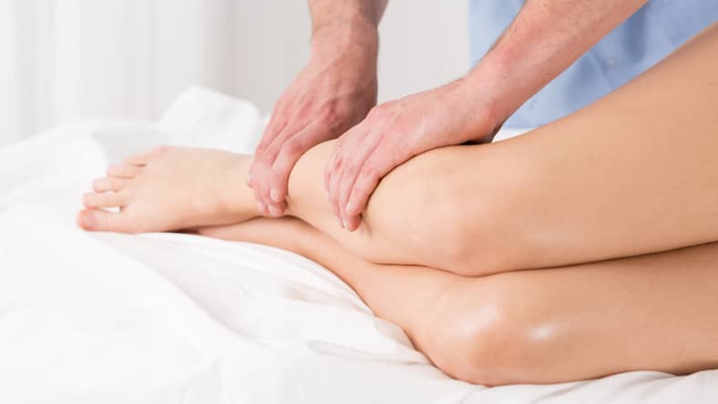 woman receiving a lymphatic massage on her legs