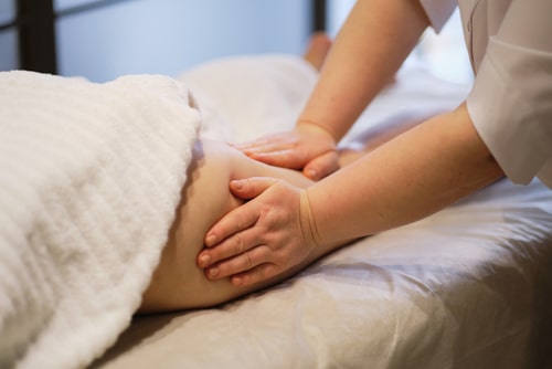 Masseur makes anticellulite massage young woman in spa salon.