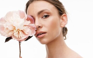 beautiful caucasian young shirtless woman holding peony flower